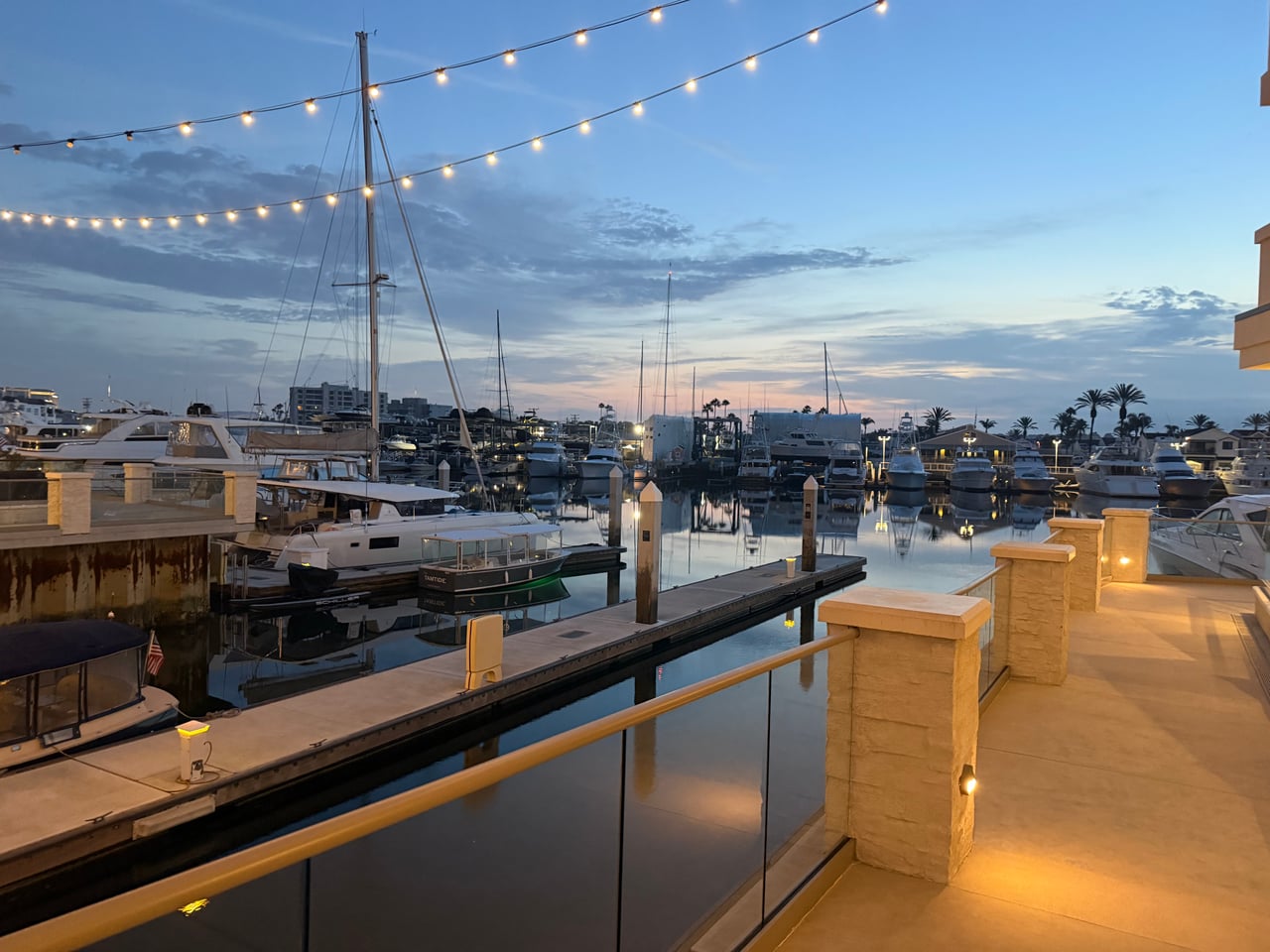 Boats and docks beside Peninsula Village in Newport Beach at dusk