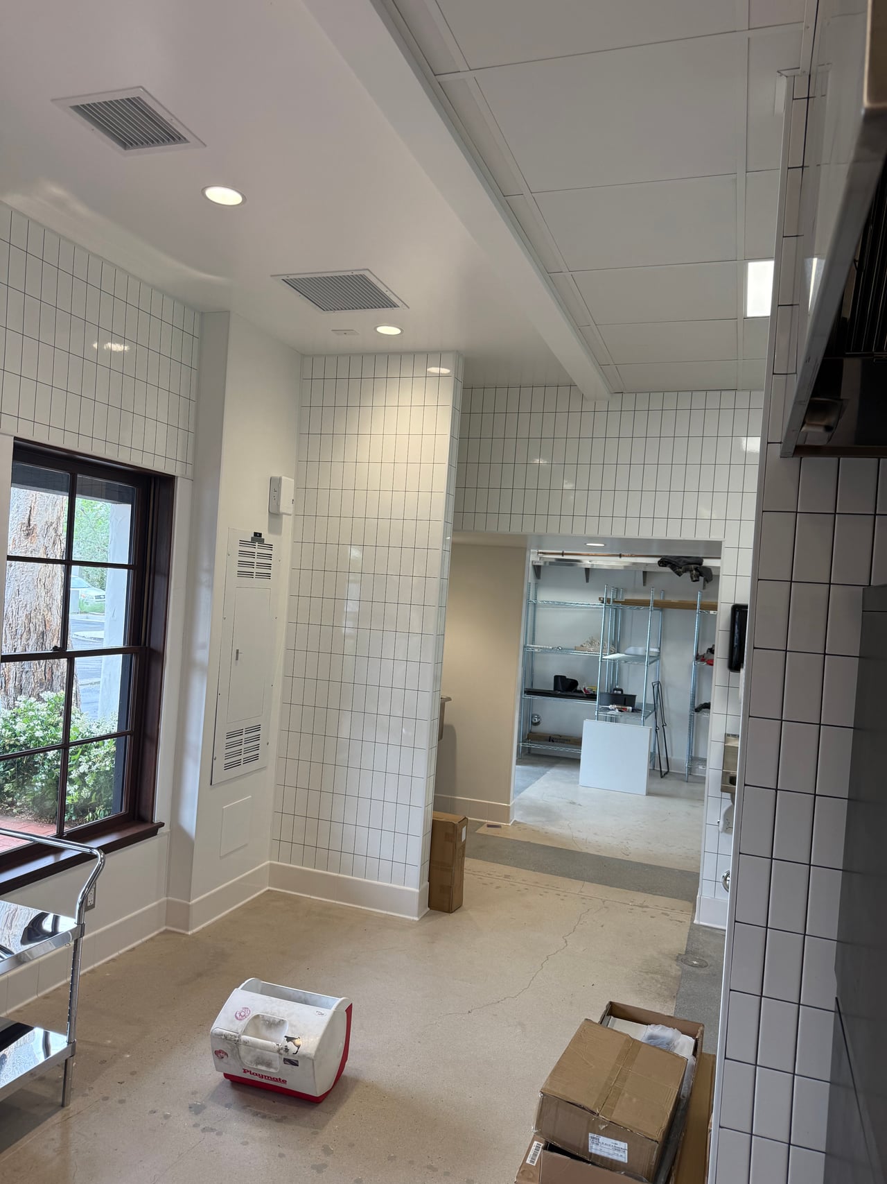 Recessed lights illuminate the tiled kitchen and prep area at Rye Goods